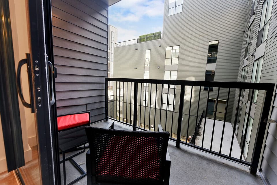 Spacious balcony with comfy patio furniture overlooking rooftops.