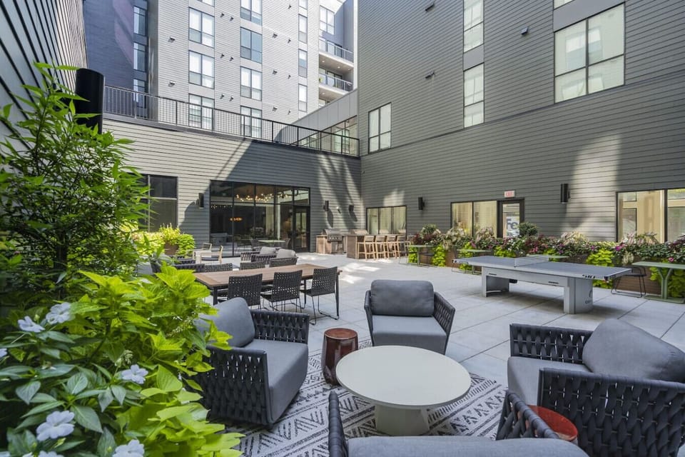 Contemporary outdoor lounge area with greenery and shade. 🪑