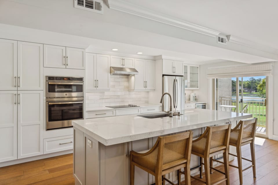 Kitchen with 3 barstools for extra seating. This kitchen also is fully stocked and has all stainless steel appliances.