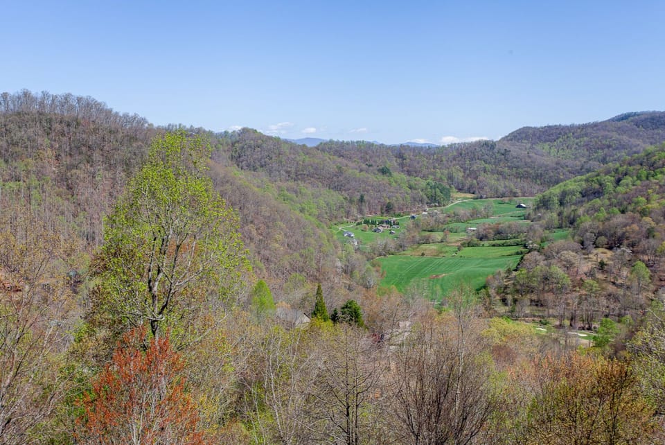 Panoramic view of forested mountains and open valleys surrounding Summit Escape in the Smoky Mountains. Natural scenery extends across the Bryson City landscape.