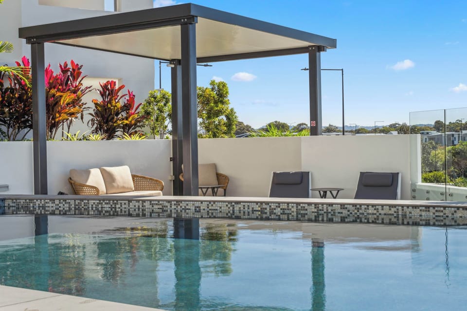Resort style swimming pool surrounded by modern landscaped spaces