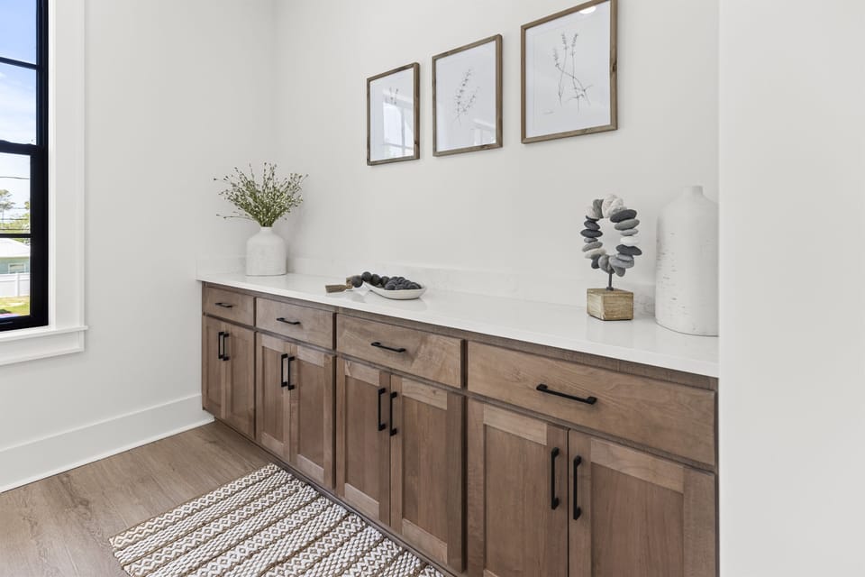 Your elegant dining room buffet offers ample storage with beautiful wood cabinetry and pristine quartz countertops for memorable meal preparations.