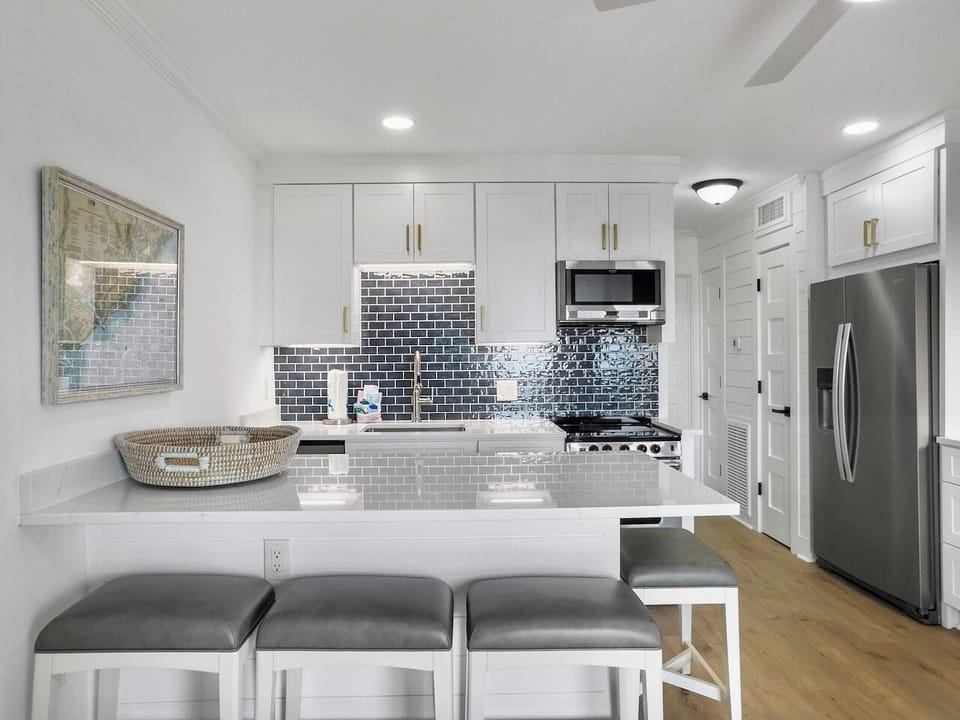 Kitchen with White Quartz Island with Seating for 4 | IOP Escapes The Admiral | Sea Cabins 307A | Top Floor Luxury Oceanfront Condo