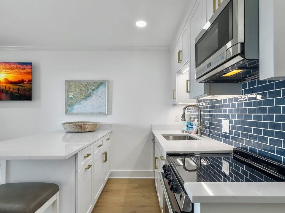 Kitchen with White Quartz Island with Seating for 4 | IOP Escapes The Admiral | Sea Cabins 307A | Top Floor Luxury Oceanfront Condo