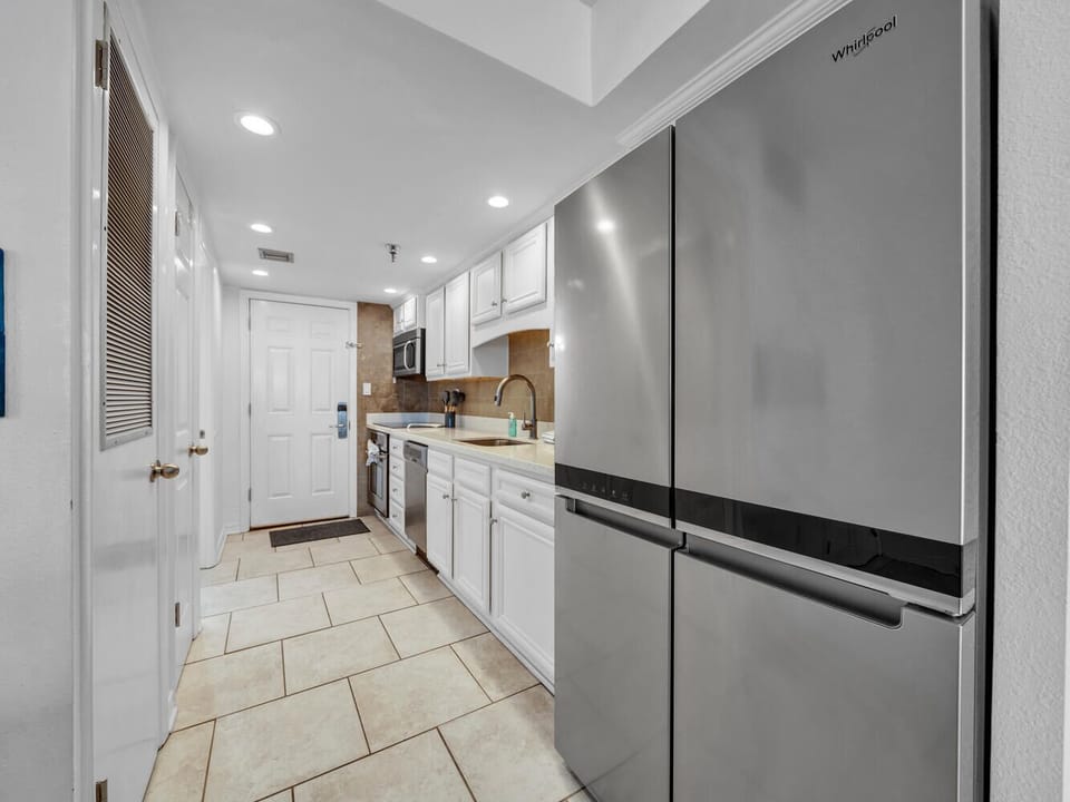 Your fully equipped galley kitchen features stainless steel appliances and crisp white cabinetry for effortless meal preparation.