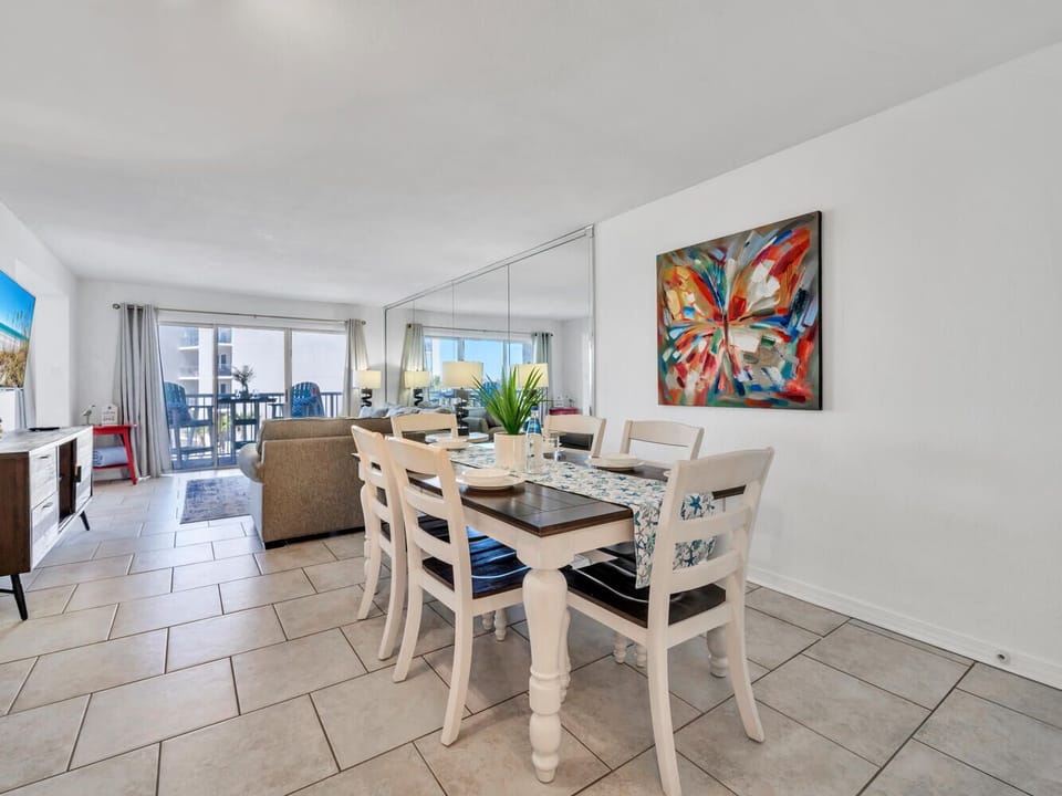 Gather around your stylish dining table where vibrant artwork and gulf views create the perfect backdrop for memorable meals together.