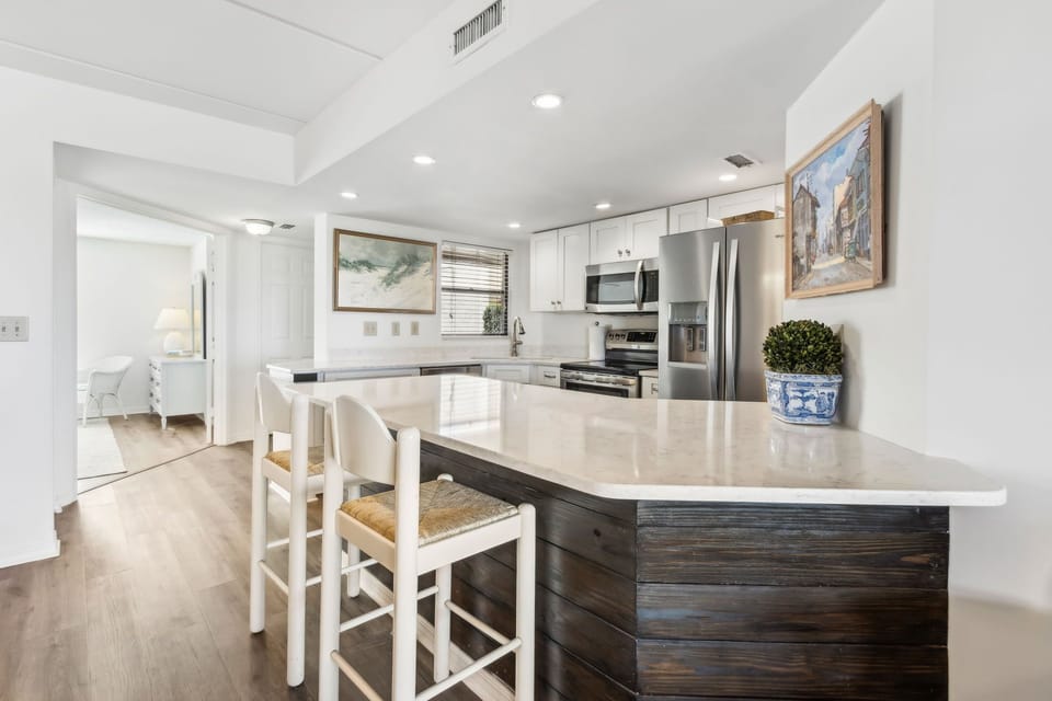 Luxury Kitchen Featuring Stainless Steel Appliances, A Shiplapped Island, and Quartz Countertops
