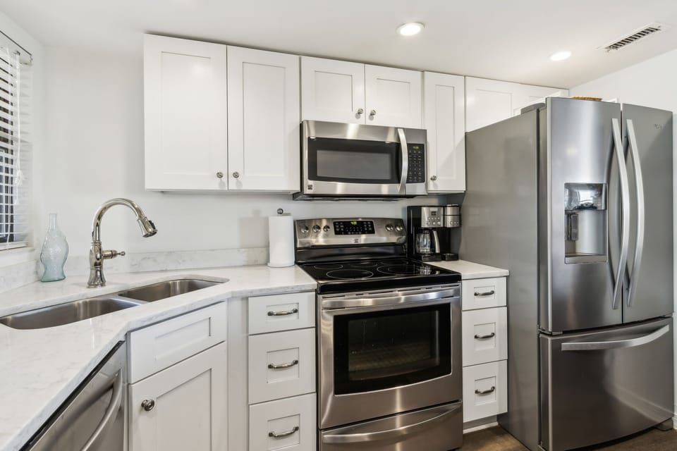 Luxury Kitchen Featuring Stainless Steel Appliances, A Shiplapped Island, and Quartz Countertops