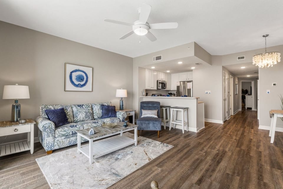 Bright coastal living space with queen sleeper sofa, Smart TV, and expansive views of the Gulf through sliding glass doors to the balcony