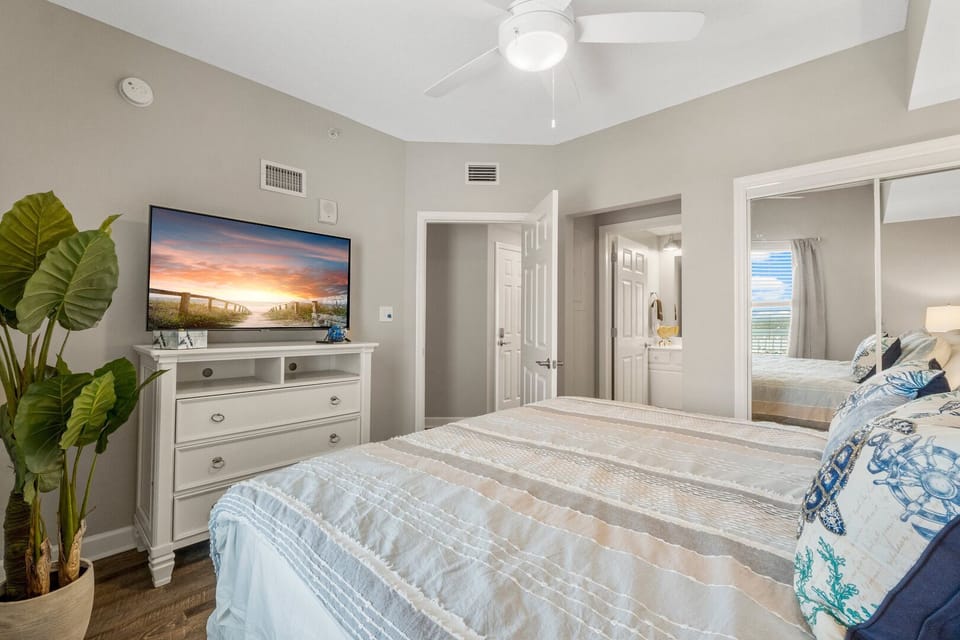 Master bedroom with a king-sized bed, flat-screen smart TV, and a private full bathroom
