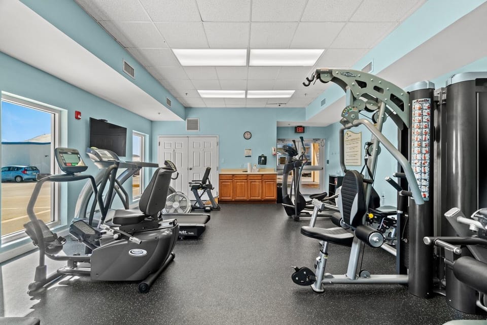 A well-equipped fitness center featuring stationary bicycles, step machines, treadmills, free weights, and more, available from 9 AM to 10 PM.