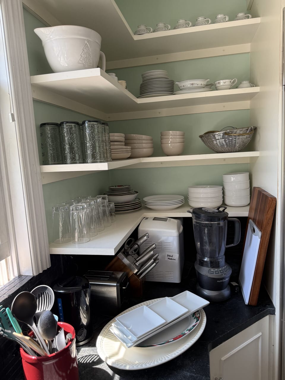 Kitchen shelf with various wine glasses,  plates and bowels 
