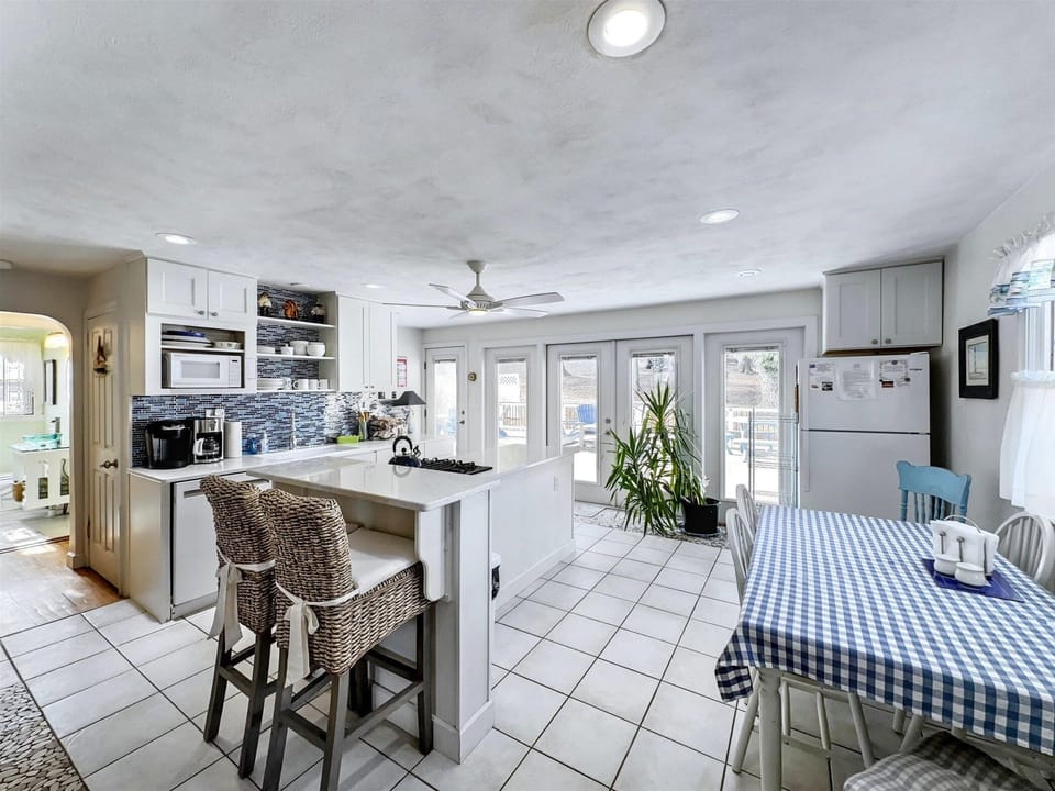Bright and airy kitchen and dining space, featuring a charming farmhouse table and plenty of natural light.