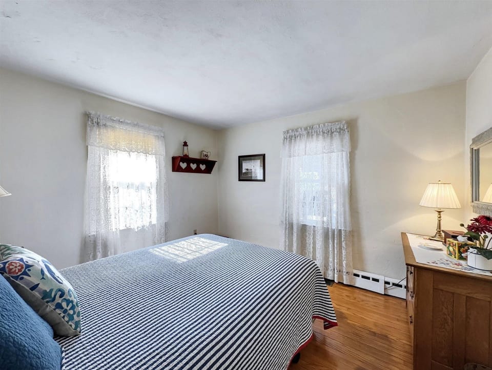 This cozy bedroom features a queen-sized bed, soft natural light, and classic decor.