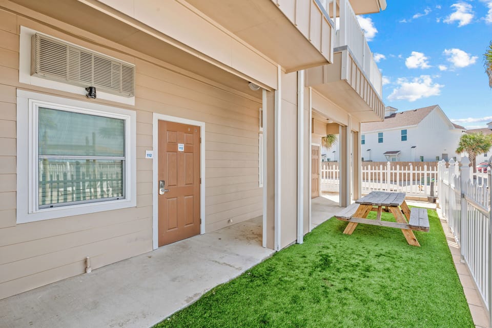 Front door of condo and a picnic table to enjoy