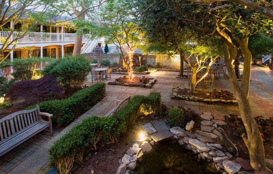 Cozy seating nestled among beautifully landscaped gardens, offering a perfect blend of nature and comfort.