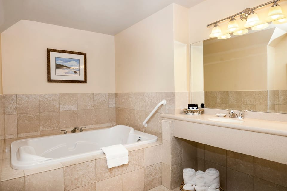 Luxurious bathroom retreat featuring a deep soaking tub, elegant lighting, and a spacious vanity for a spa-like experience.