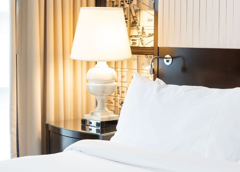Elegant bedside ambiance, where warm lighting and plush bedding create a cozy retreat.