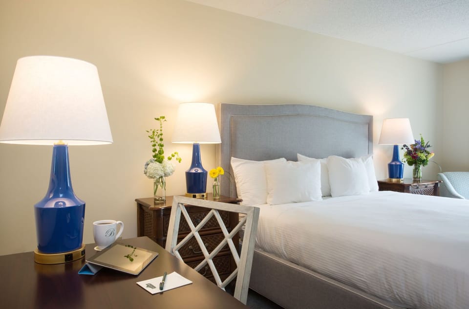 A beautifully designed bedroom featuring elegant lighting, plush bedding, and a cozy workspace for ultimate comfort.