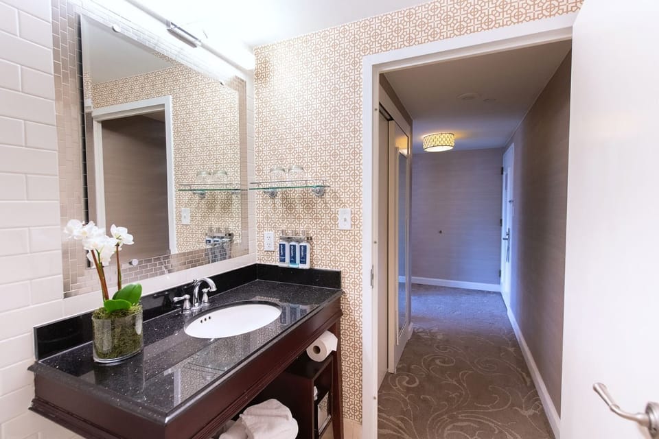 Elegant and modern bathroom, featuring sleek countertops, warm lighting, and thoughtful amenities for a refreshing stay.