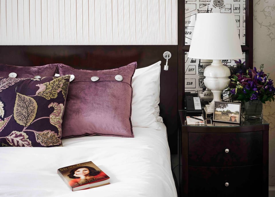 Elegant bedside retreat, with rich textures and warm lighting for a cozy and refined ambiance.