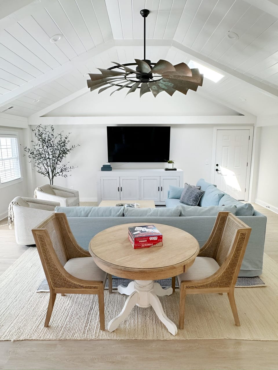 Large, light-filled family room with smart TV and game table.