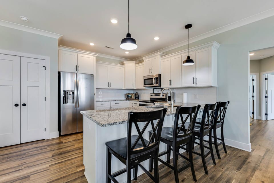 Kitchen area featuring a refrigerator and a breakfast bar with seating for 4 — ideal for quick meals and casual dining.