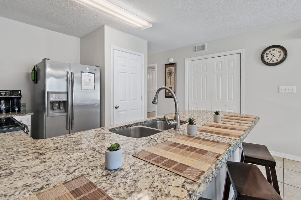 A bright granite kitchen with bar seating and full appliances.