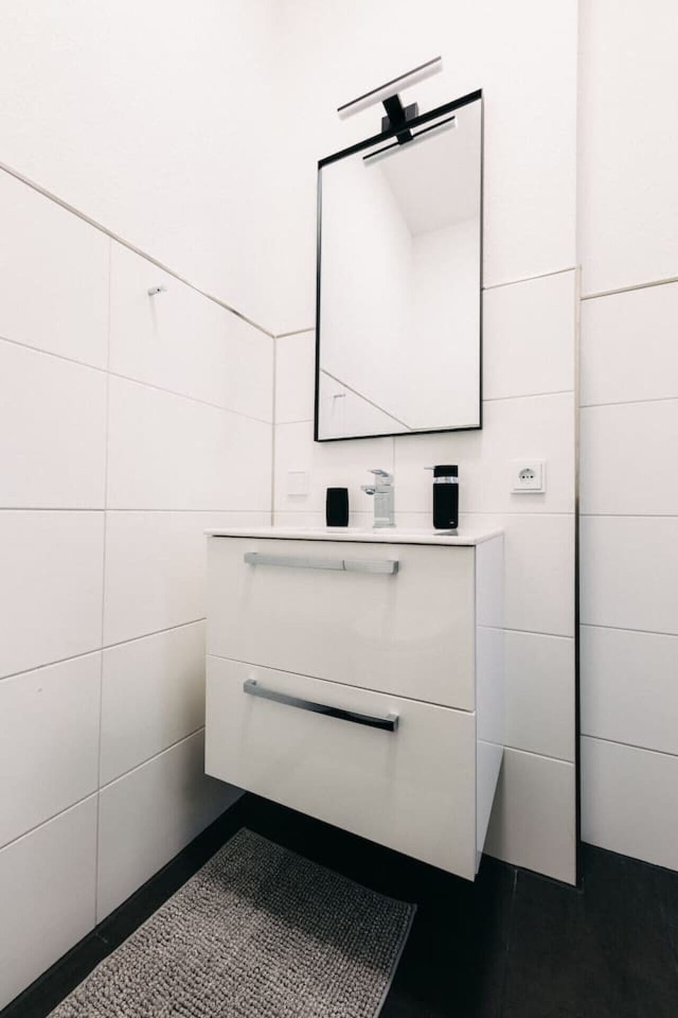 Modernes Badezimmer-Design. Der stilvolle Spiegel mit LED-Licht und der elegante Waschtisch bieten Funktionalität und Ästhetik zugleich. Perfekt für einen erfrischenden Start in den Tag!