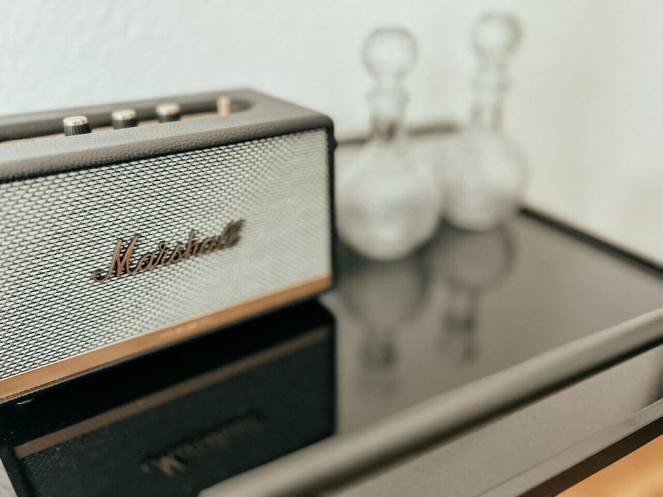 Perfekte Klangkulisse für deinen Aufenthalt! Der Marshall-Speaker bringt satten Sound in dein Apartment. Lehne dich zurück, genieße deine Lieblingsplaylist und erlebe das besondere Flair dieses stilvollen Rückzugsorts.