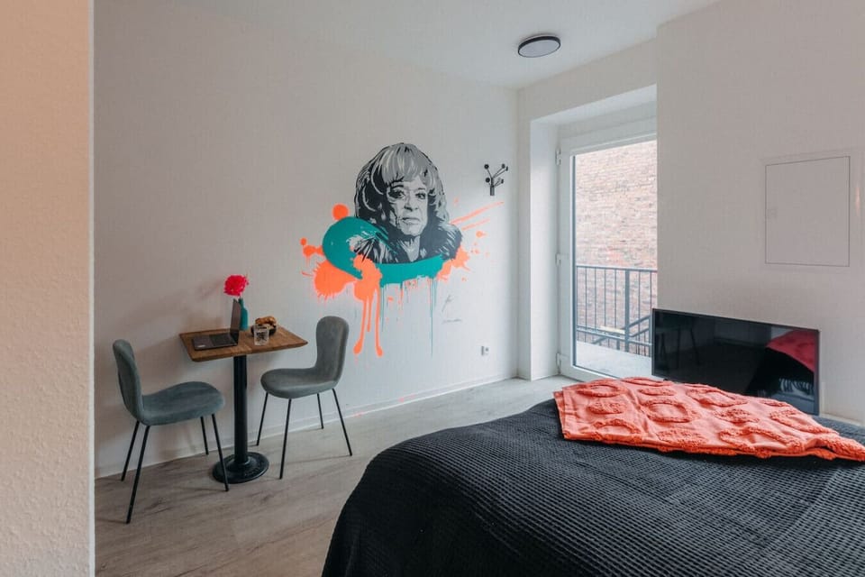 Apartment mit Charakter: Das moderne Design trifft auf urbanen Streetart-Charme. Das Wandgemälde setzt einen kunstvollen Akzent, während der gemütliche Essbereich zum Verweilen einlädt. Lichtdurchflutet und stilvoll – dein perfekter Rückzugsort!
