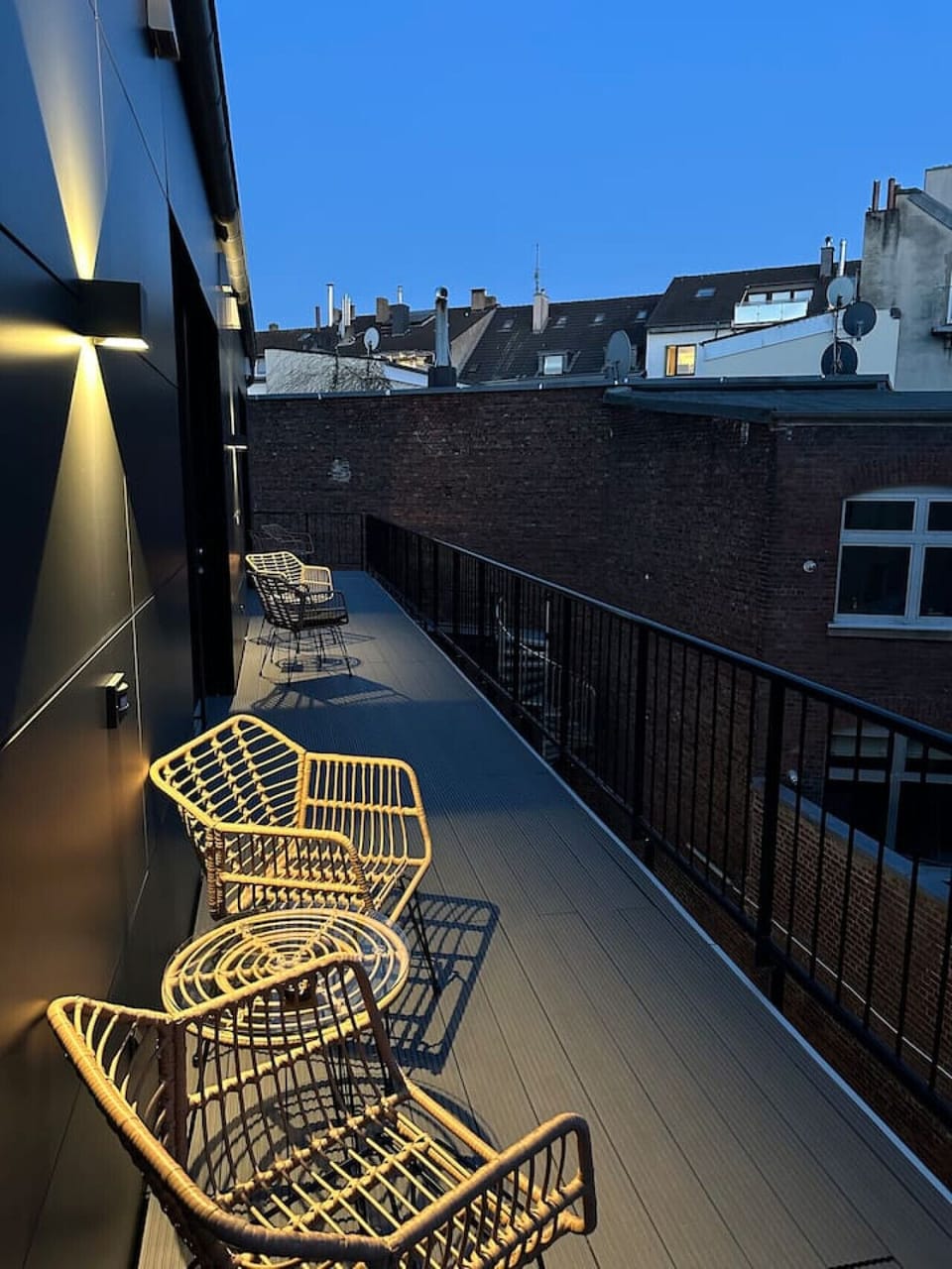 Genieße den Abend auf dem stilvollen Balkon mit Blick über die Dächer der Stadt – ein perfekter Ort für einen entspannten Ausklang des Tages.