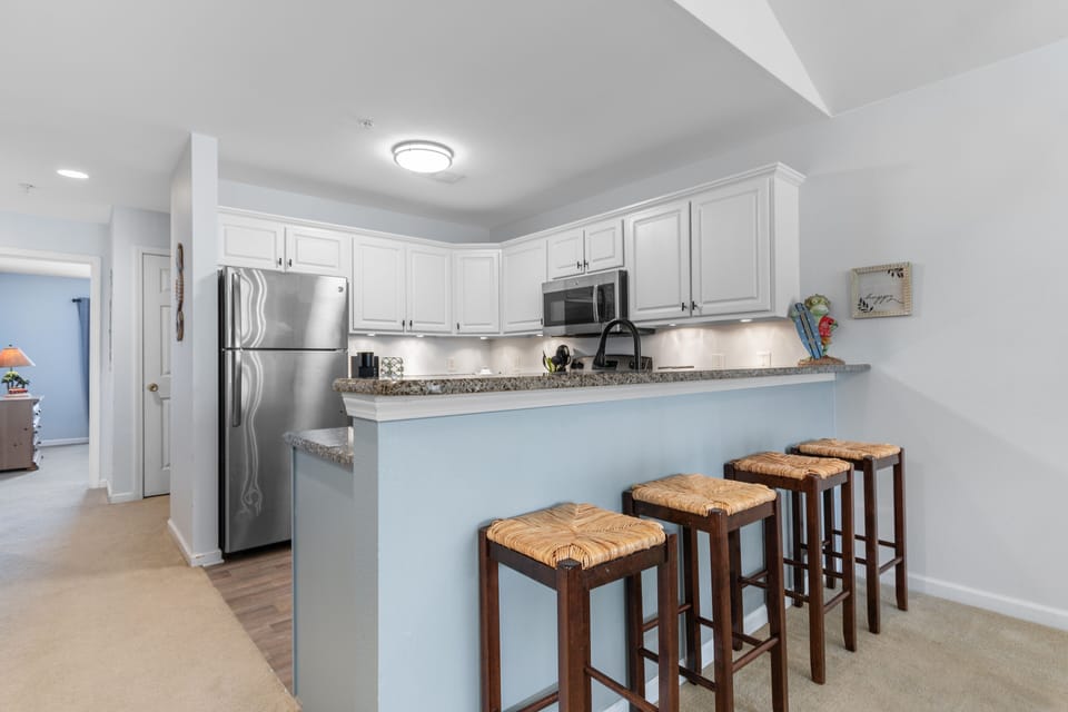 Your fully equipped kitchen awaits with granite counters, stainless appliances, and a breakfast bar where you can sip morning coffee.