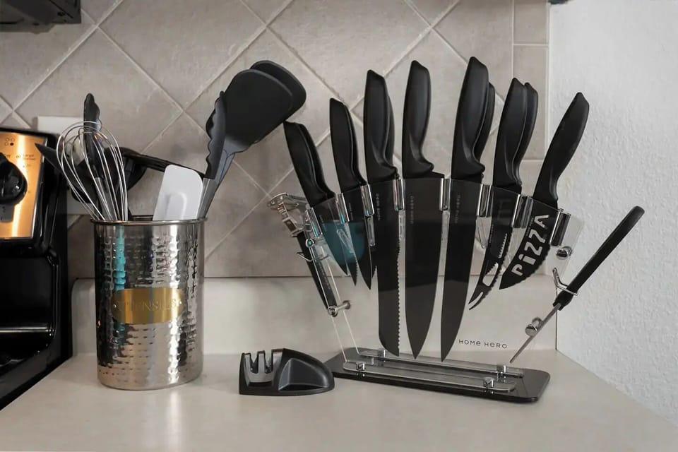 This well-equipped kitchen showcases a set of sharp knives and essential cooking utensils neatly arranged for convenience. Modern appliances and ample counter space make it perfect for culinary adventures and meal prep.

