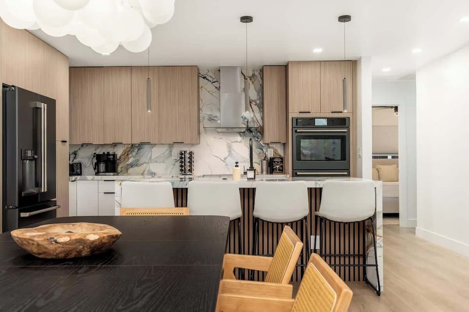 Gather around the sleek marble island where morning coffee and evening conversations flow effortlessly. Modern appliances and elegant finishes make your meal prep a breeze.