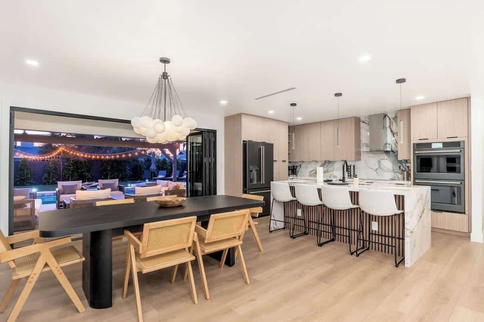 Your dream gathering space: cook, dine, and socialize in this elegant open kitchen and dining area that flows to your private outdoor oasis with twinkling lights overhead.