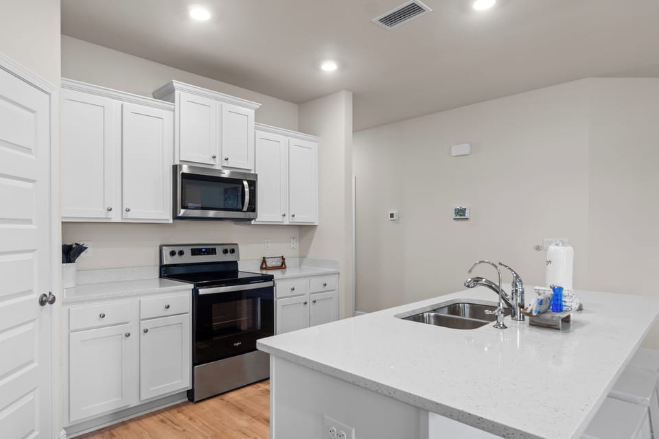 Your fully equipped kitchen features sleek white cabinets, granite countertops, and modern appliances for all your culinary adventures.