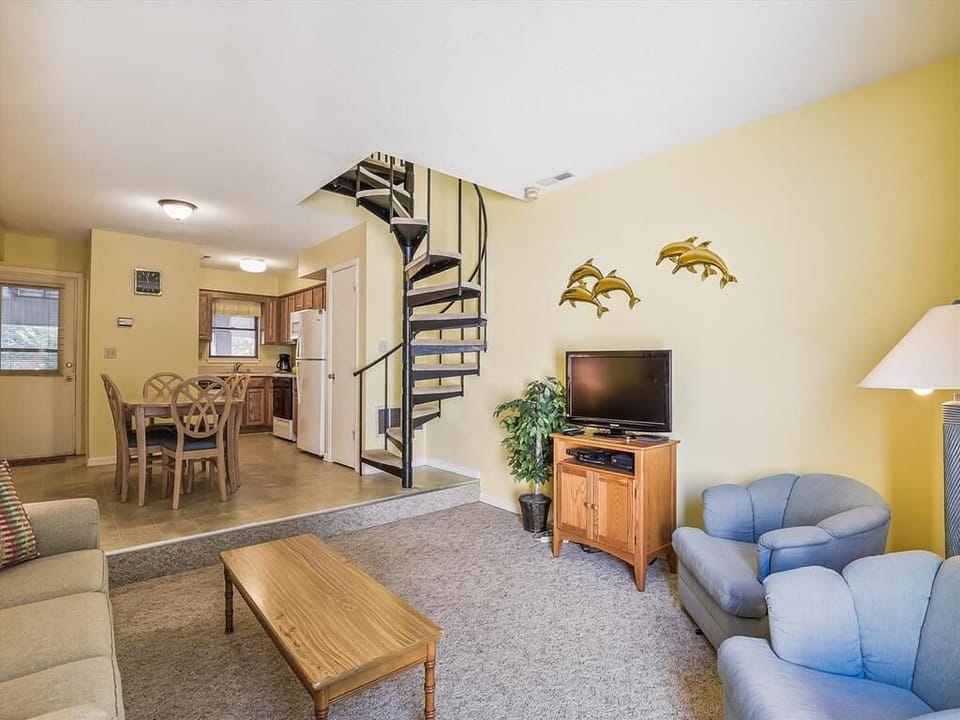 Experience the inviting family-friendly layout of this townhome, showcasing a spiral staircase that leads to cozy living spaces and a full kitchen for all your dining needs.