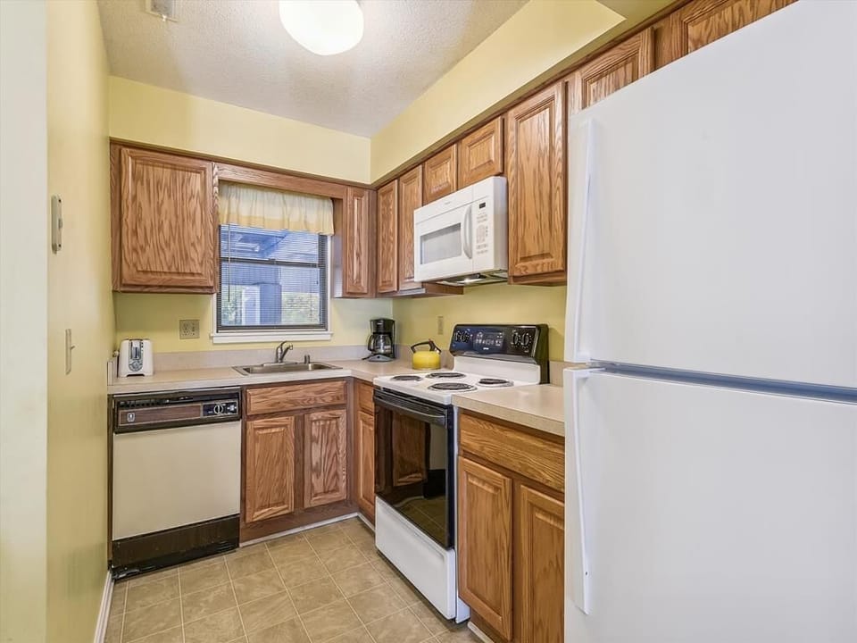 The well-designed kitchen boasts modern appliances including a dishwasher and microwave, perfect for preparing meals during your beach getaway.