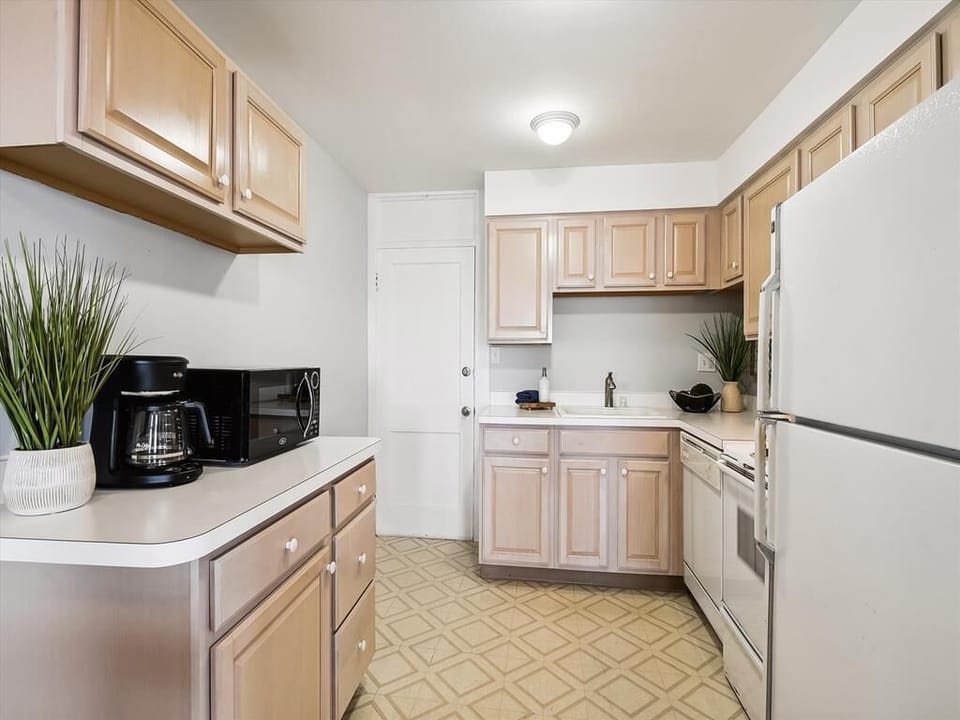 A closer view of the kitchen, featuring a coffee maker, microwave, and a well-lit cooking space.