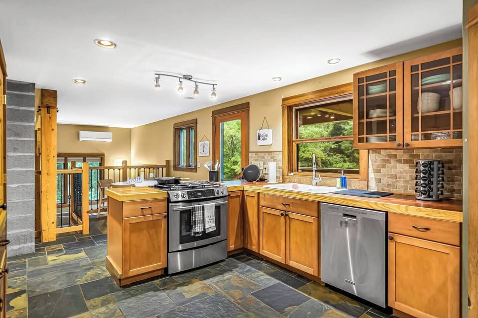 Modern kitchen with a gas stove, dishwasher, pantry, fridge, and toaster oven.