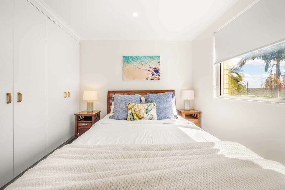 Relaxing second queen bedroom with hotel quality linen and welcoming coastal styling