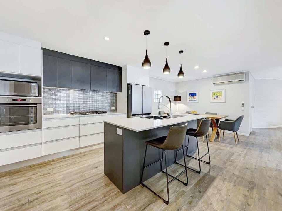 The modern kitchen is fully-equipped with stainless steel appliances. A central island provides ample food prep space and additional seating.