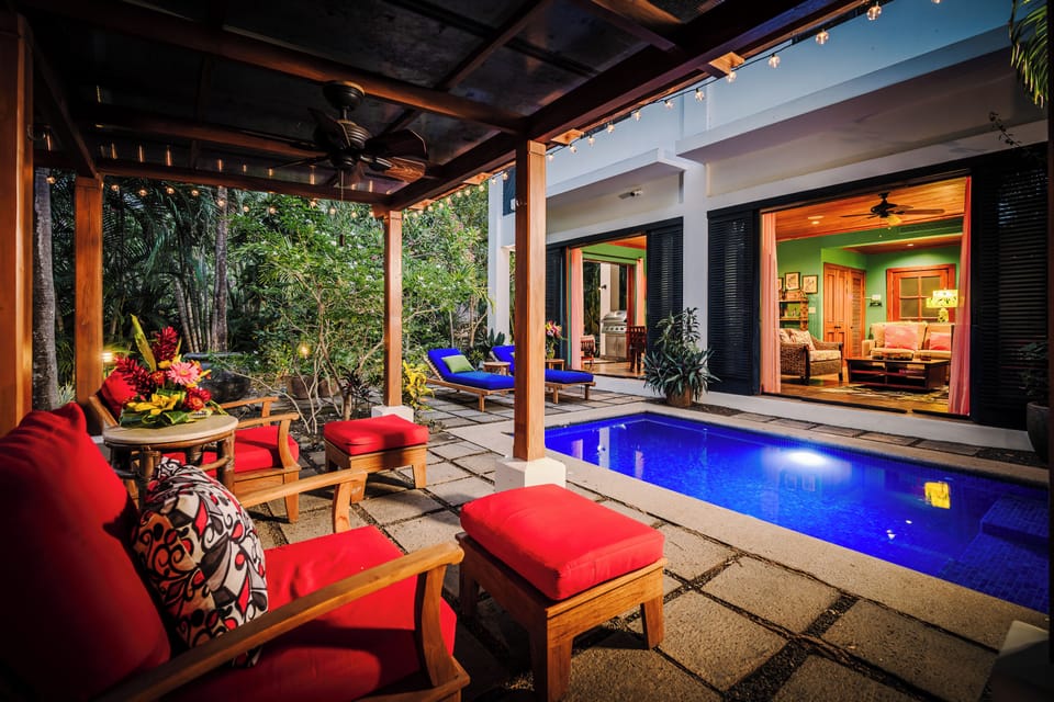 Cozy bungalow lounge area overlooking the pool, open-concept house, and living room interior at this Langosta luxury vacation rental. Tropical garden views, fine art decor, peaceful atmosphere, perfect for indoor-outdoor coastal living in Tamarindo.