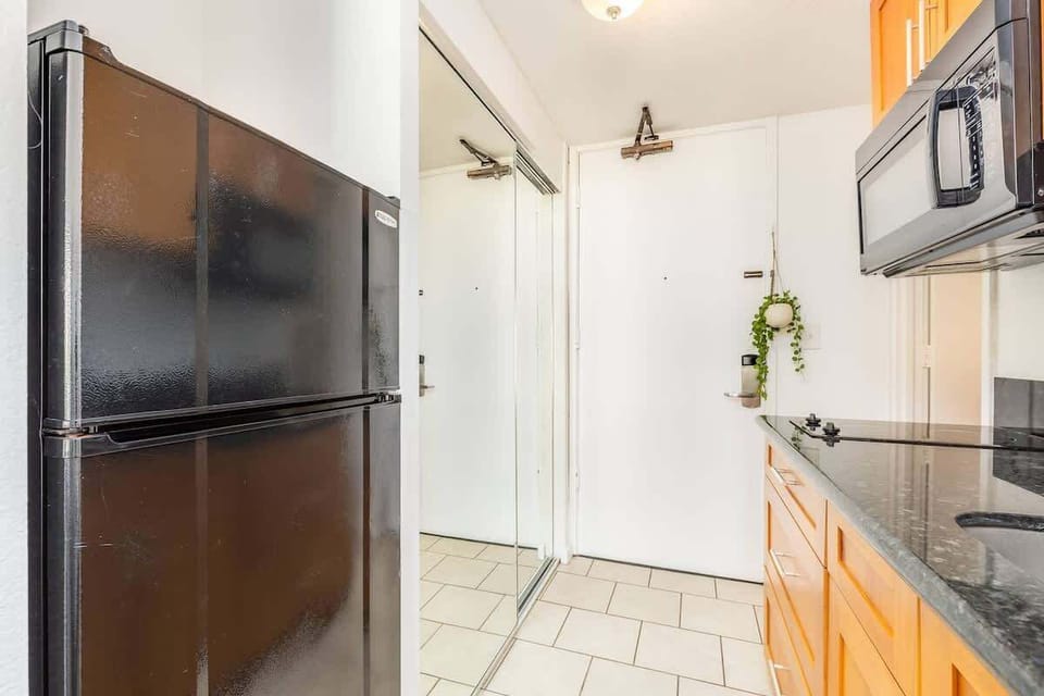 Kitchenette setup with microwave, sink, fridge and storage