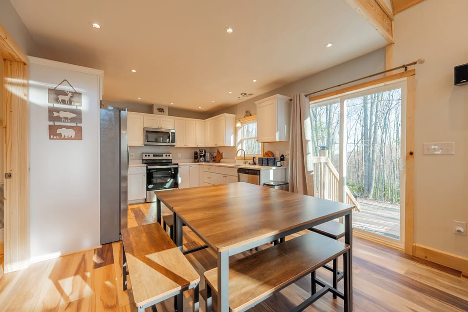 Bright kitchen and dining area with big windows and forest views.