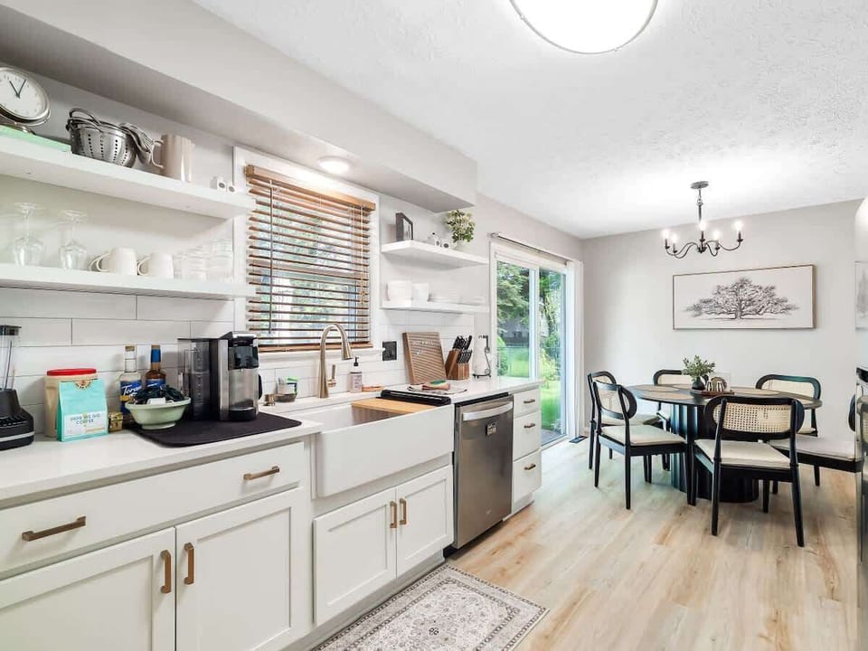 Bright kitchen w/ white cabinetry, open shelving & space to cook w/ ease