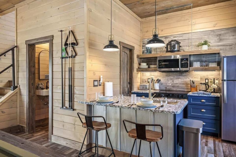 Cook up your favorites in this fully equipped kitchen featuring granite countertops, stainless steel appliances, and open shelving with all the essentials for a cozy night in.