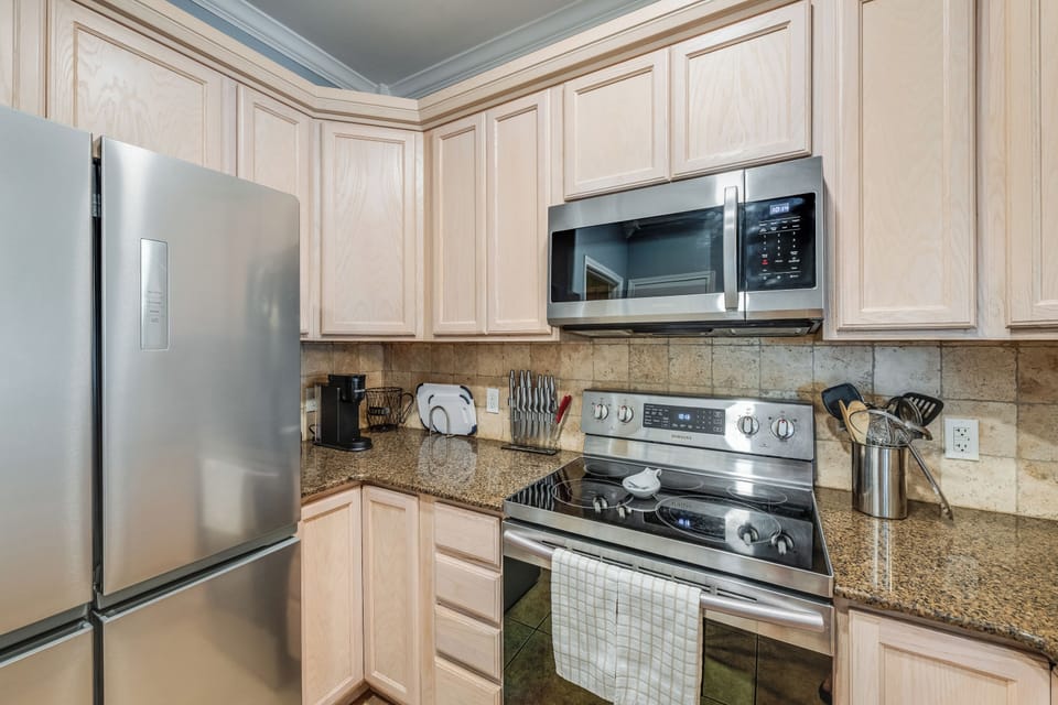 Your fully equipped kitchen features granite counters, stainless appliances, and elegant cabinetry for preparing memorable meals during your stay.