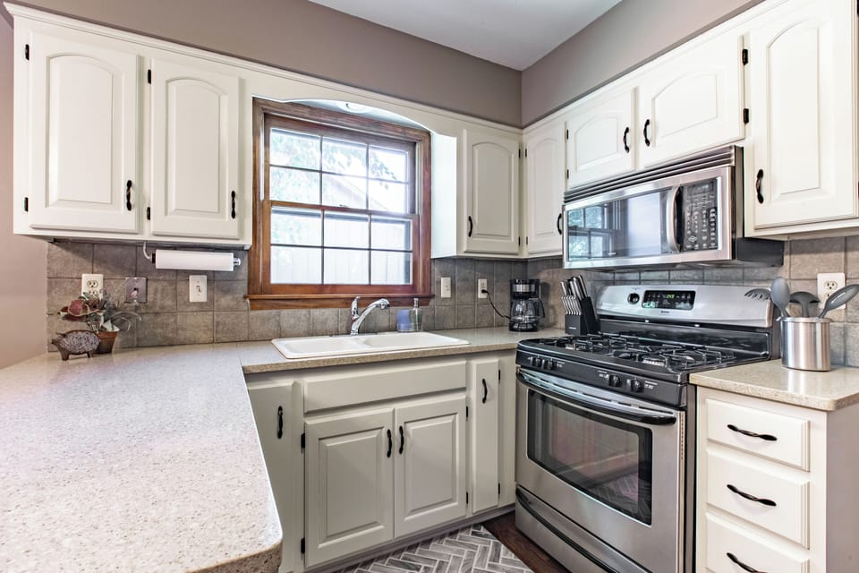 The kitchen offers ample counter space for meal preparation and includes a window for natural light. The warm color palette and comfortable layout create a welcoming atmosphere for cooking and enjoying meals.